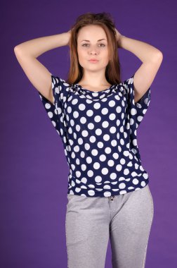 Güzel genç kız mor bir arka plan üzerinde poz