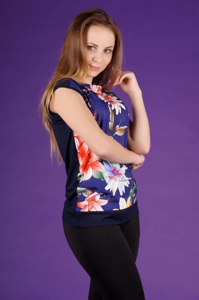 Beautiful young girl  posing on a purple background — Stock Photo, Image