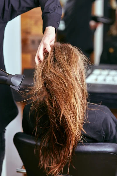 Secar, peinar el cabello de las mujeres en un salón de belleza — Foto de Stock