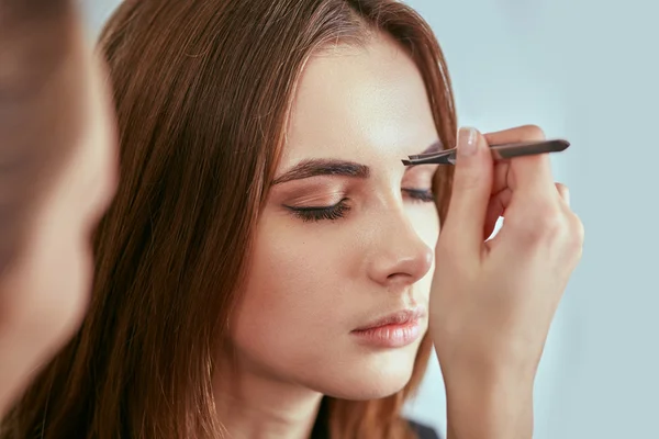 Beautiful young girl got correction of eyebrows in a beauty salon