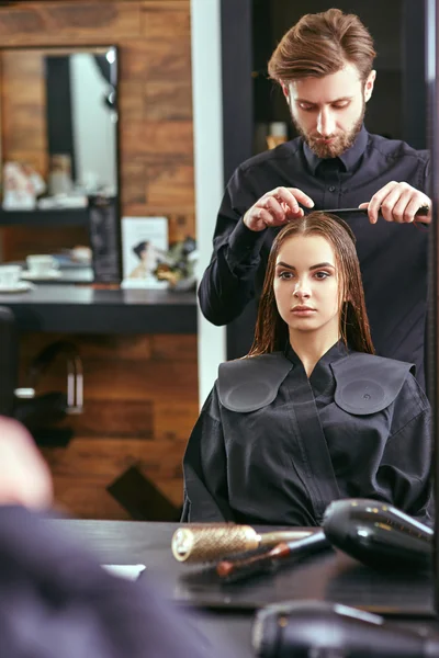 Peluquero hace un corte de pelo femenino en el salón de belleza para una chica joven y hermosa — Foto de Stock