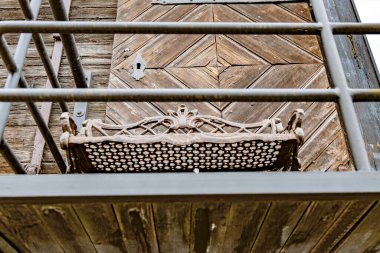 Beton bir iskelede balık tutan, elinde olta olan küçük bir sandalyede oturan, arkasında sert ve liman vinci olan gri bir savaş gemisinin düşük açılı geniş açılı görüntüsü..