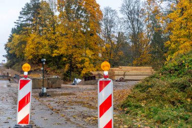 İnşaat alanındaki kırmızı ve beyaz çizgili trafik ışıklarını kapatın. Güvenlik ekipmanları ve altyapı bakımına odaklan.