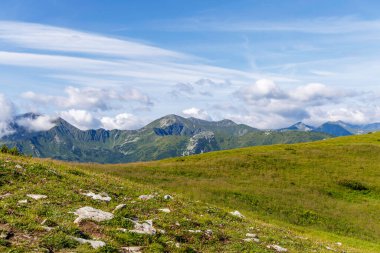 Yeşil dağ sırtlarının ve Tatra Ulusal Parkı 'ndaki parlak bir yaz gökyüzünün altındaki kayalık tepelerin büyüleyici panoramik manzarası..