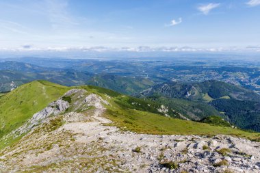 Yeşil tepeler boyunca uzanan kayalık yürüyüş yolunun manzarası vadi manzarası ve Tatra Ulusal Parkı 'ndaki uzak bulutlar..