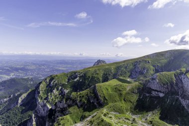 Kayalık dağ sırtlarının ve Tatra Ulusal Parkı 'ndaki parlak mavi bulutlu, mavi gökyüzünün altındaki yeşil yamaçların muhteşem panoramik manzarası..