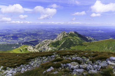 Zakopane kasabasına bakan Iconic Giewont dağı zirvesi. Tatra 'dan yüksek açı manzarası yeşil bir dağ vadisinde yerleşik kentsel gelişimi gösteriyor..
