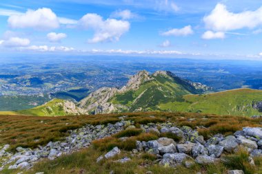 Zakopane kasabasına bakan Iconic Giewont dağı zirvesi. Tatra 'dan yüksek açı manzarası yeşil bir dağ vadisinde yerleşik kentsel gelişimi gösteriyor..