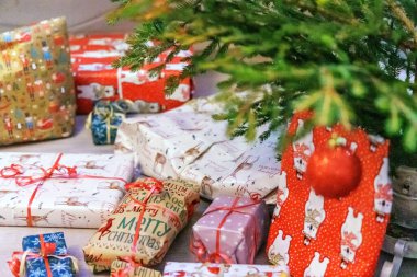 Bir Noel ağacının dallarının altına yerleştirilmiş pek çok paketlenmiş hediye kutusunun yer aldığı tatil kompozisyonu. Kış indirimi ve şenlikli promosyonlar için mükemmel..