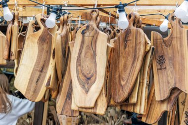 Benzersiz tahıl desenleri olan ahşap kesme tahtaları ve açık hava hediyelik eşya tezgahında asılı Zakopane markaları..