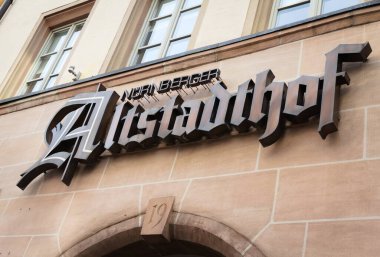 Nuremberg 'deki taştan bir binanın ön cephesinde büyük bir Altstadthof tabelasına yakın plan, üzerinde geleneksel mimari unsurlar sergileniyor..