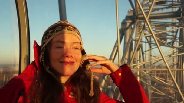 Mujer joven y hermosa sonriendo y mirando hacia adelante desde la altura en la rueda de los hurones — Vídeos de Stock