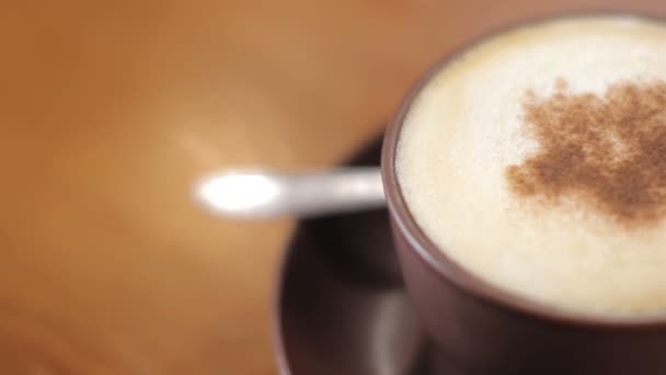 Tasse de cappuccino avec de la poudre de cannelle sur la barre, toboggan — Video