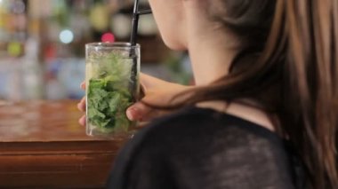 Genç kadın içecekler mojito. Arkadan vurdu