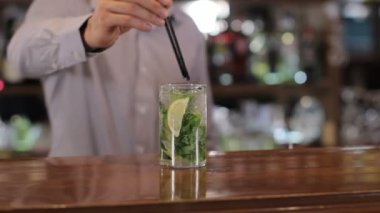 Barmen mojito ahşap bar sayacı sunmaktadır.