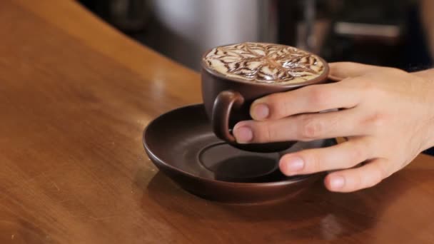 Bartender serves coffee cappuccino on wooden bar counter. Girl picks it up. Close up — Stock Video