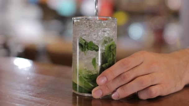 Bartender mixes mojito on wooden bar counter — Stock Video