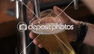 Barmen bardak fıçı bira döküyor. Yakın çekim