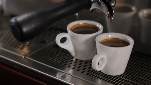 Barista plockar upp två koppar färska gjorde espresso. På nära håll — Stockvideo