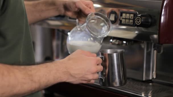 Barista gieten melk in een werper. Close-up — Stockvideo