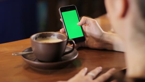 여자 녹색 스크린 및 음료 커피 스마트폰으로 작동합니다. 뒤에서 총 — 비디오