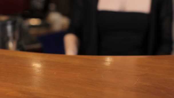 Bartender put a teapot and a cup on wooden bar counter. Medium shot — Stock Video