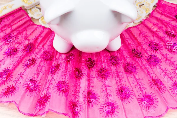 White piggy bank on a pink fan up close