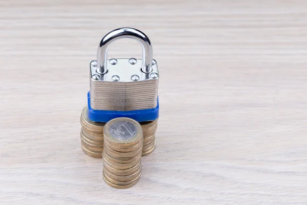 Padlock on a stack of coins on a table