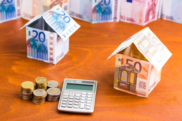 Banka notlar bir hesap makinesi ve para ile yapılmış ev
