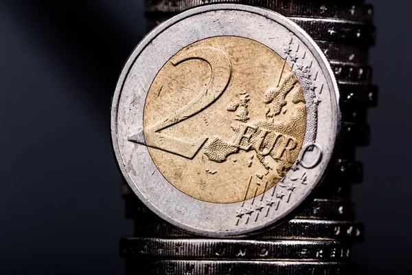 Karanlık bir arka plan ile bir iki euro madalyonun yakın çekim