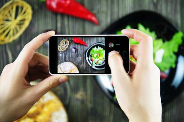 sosis ve domuz pirzolası fotoğraf çekmek için akıllı telefonlar kullanan arkadaşlar.