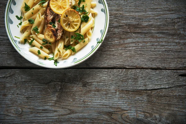 Somon fileto tagliatelle, otlar, limon, üstten görünüm, penne makarna