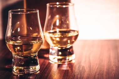 Kırsal ahşap arka planda seçici odaklanmış viski bardakları, barda tezgahta içki içerken viski ya da ahşap masada buz küpleriyle viski içmek..