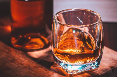 Kırsal ahşap arka planda seçici odaklanmış viski bardakları, barda tezgahta içki içerken viski ya da ahşap masada buz küpleriyle viski içmek..