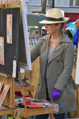 PARIS, FRANCE - APRIL 20, 2015: An artist drawing at Place du Tertre, an open-air workshop with its 288 official painters on Montmartre