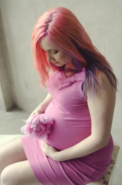 Mulher grávida com flor rosa — Fotografia de Stock