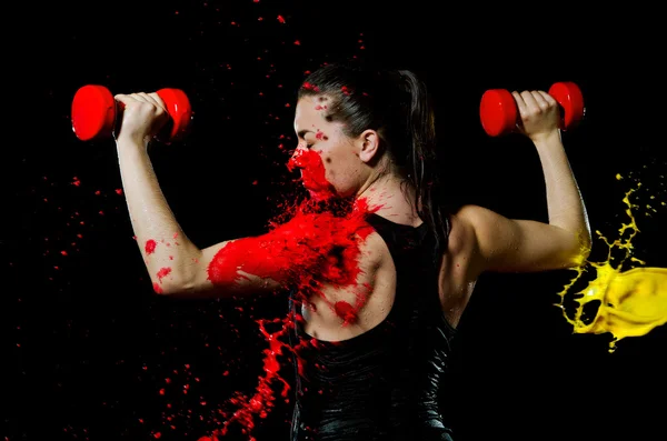 Menina atlética com halteres manchados com tinta — Fotografia de Stock