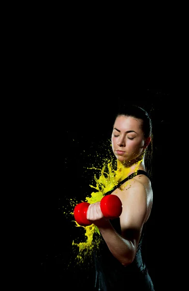 Flickan gör övning för biceps badar i gul färg — Stockfoto