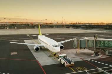 Terminal kapısında kalkışa hazır uçak - Gün doğumu sırasında modern uluslararası havaalanı - Dünya çapında seyahat
