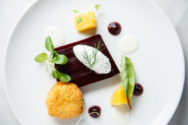 Pancar terrine, keçi peyniri kroket, yabanturpu sosu ve beyaz çanak üzerine dereotu krem