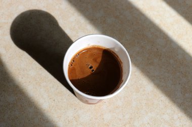 Masanın üzerinde bir fincan kahve.      