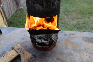 Kızarmış et kebabını ateşe verdikten sonra şöminede parlak bir ateşle odun yakmak. Ormanda piknik. 