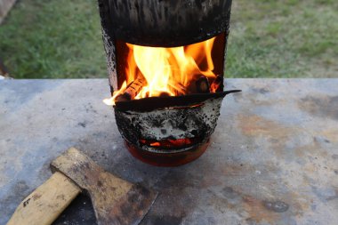Kızarmış et kebabını ateşe verdikten sonra şöminede parlak bir ateşle odun yakmak. Ormanda piknik. 