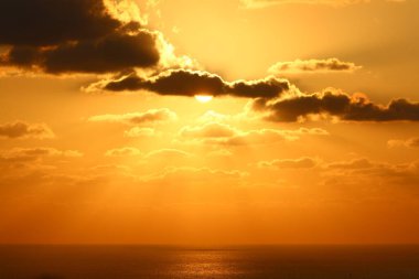 Gün batımında gök gürültülü bulutların ve kızıl gökyüzünün arka planına karşı Yıldız Güneşi 