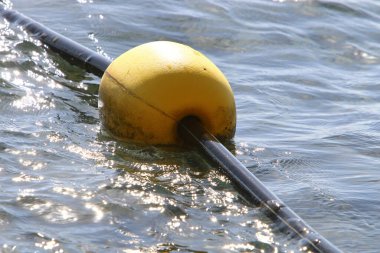 Akdeniz kıyısında kumlu bir sahilde yüzen şamandıralı bir ip. Güneşli bir günde deniz kıyısında. 