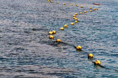 Akdeniz kıyısında kumlu bir sahilde yüzen şamandıralı bir ip. Güneşli bir günde deniz kıyısında. 
