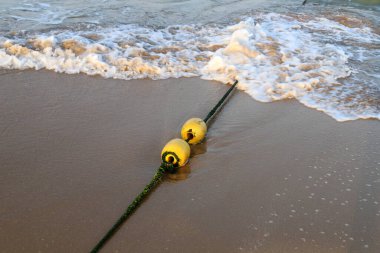 Akdeniz kıyısında kumlu bir sahilde yüzen şamandıralı bir ip. Güneşli bir günde deniz kıyısında. 