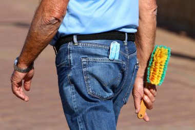 Tıbbi yüz maskesi kişinin elinde asılı ve korona virüsüne karşı hiçbir koruma yok. Maske bir insanı virüslerden korumalı. 