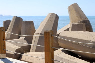 Akdeniz kıyılarındaki fırtına dalgalarından sahili korumak için dalgalı sulara devasa beton bloklar ve büyük taşlar konur. 