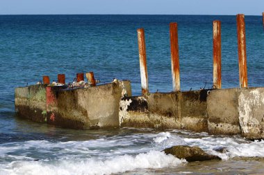 Akdeniz kıyılarındaki fırtına dalgalarından sahili korumak için dalgalı sulara devasa beton bloklar ve büyük taşlar konur. 